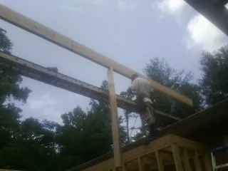 Carpenter setting a ridge beam over a new addition frame — Ice Dam Removal by Roofing Brothers in Hazel Crest