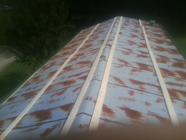 Rusted metal roof panels with new wood purlins before replacement — Storm Damage Roof Repair in Hazel Crest by Roofing Brothers