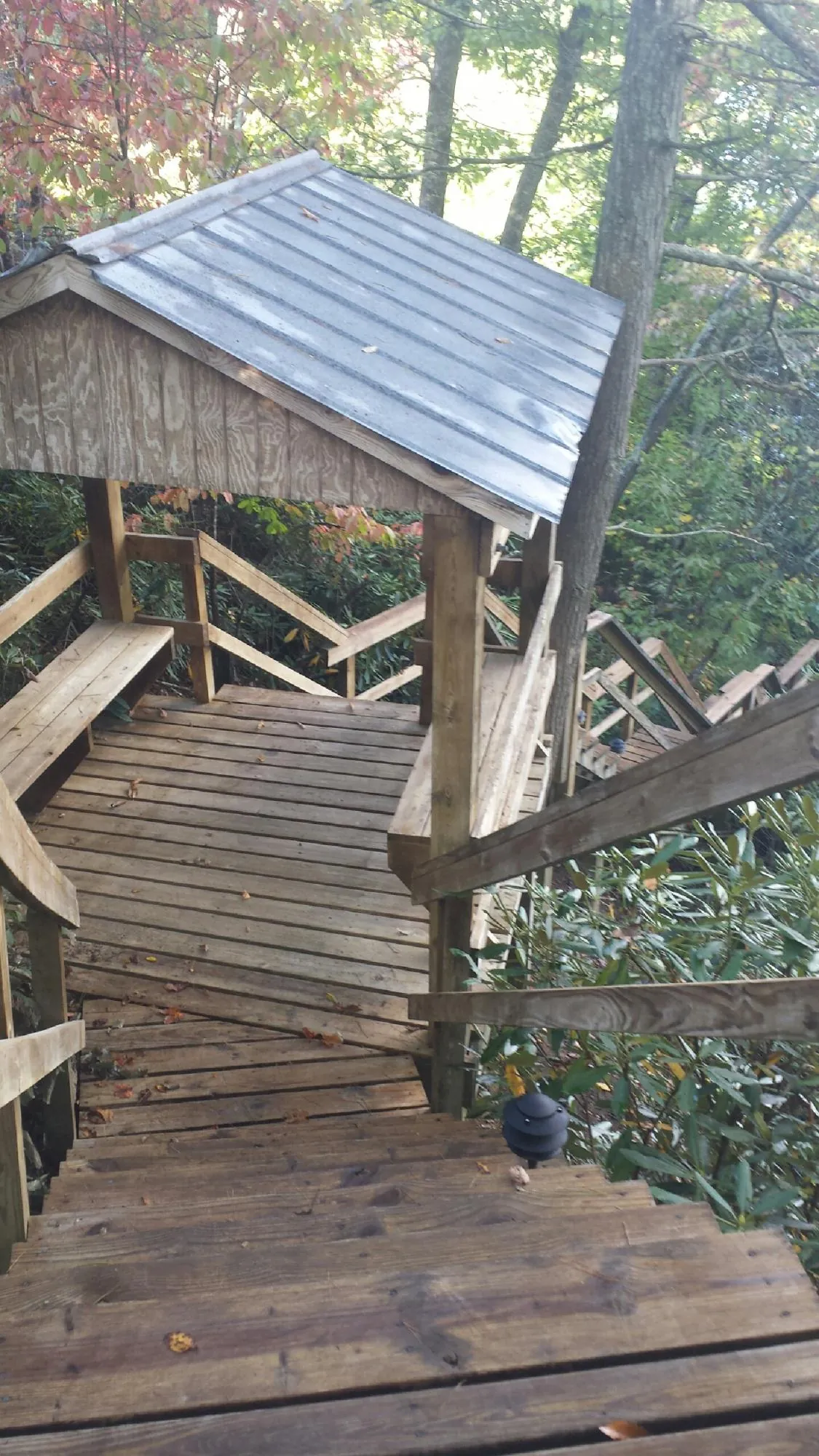 Metal roofed shelter over wooden steps on a wooded walkway — Skylight Repair & Installation work by our crew in Hazel Crest