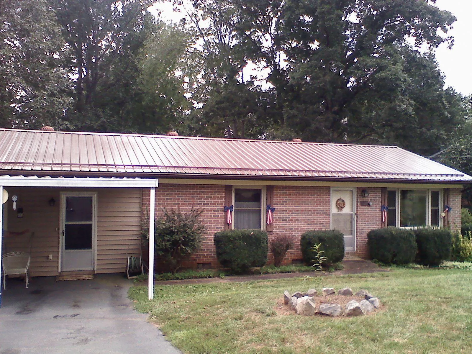 Bronze metal roof and carport on a brick ranch home — Roof Repair work by our crew in Hazel Crest